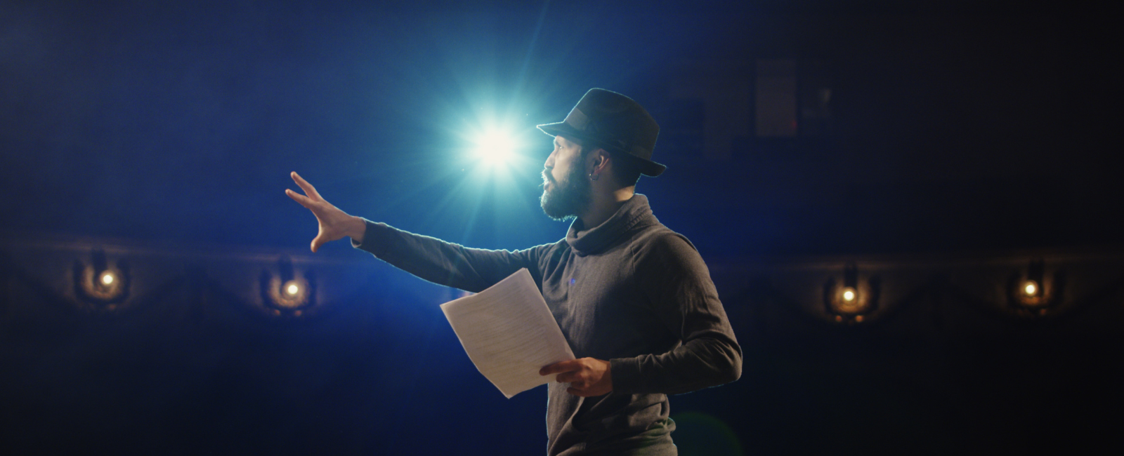 Theatre teacher on stage teaching students.