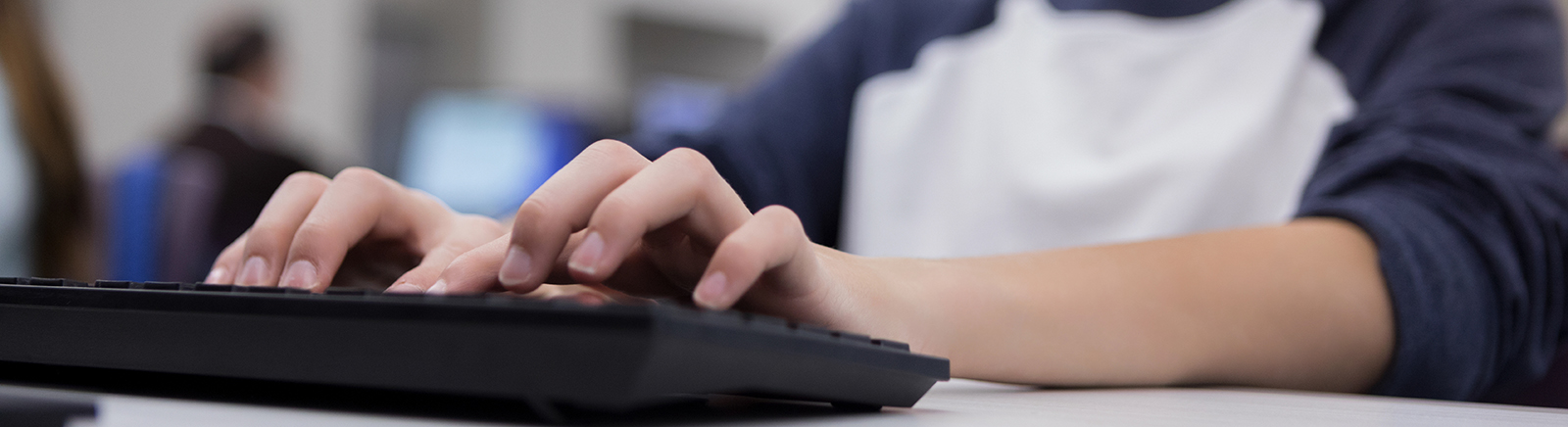 Student's hands typing on computer keyboard.